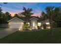 Charming single-story home featuring a two-car garage, beautifully landscaped yard, and a quaint, welcoming entrance with a teal door at 4009 Clear Spring Rd, Brooksville, FL 34604