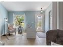 Inviting Foyer features cool colors, light tile flooring, decorative front door and an ornate chair with a patterned rug at 4009 Clear Spring Rd, Brooksville, FL 34604
