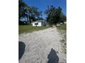 Exterior view of the property with a gravel driveway and well-maintained yard at 410 Houle Ave, Sarasota, FL 34232