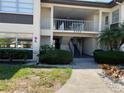 Charming condo exterior with walkway, second story balcony, and lush tropical landscaping at 4726 Marine Pkwy # 104, New Port Richey, FL 34652