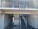 Condo exterior featuring second story balcony, stairs, and covered walkways at 4726 Marine Pkwy # 104, New Port Richey, FL 34652
