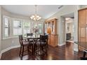 Charming dining area with dark wood floors, modern chandelier, and plantation shutters for lots of natural light at 4923 Fort Peck Rd, New Port Richey, FL 34655