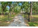 Gated driveway leading to a charming home nestled among lush trees at 5363 Utopia Pl, Brooksville, FL 34601