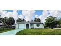 Charming single-story home featuring a light-colored exterior, attached garage, and well-maintained lawn at 5447 Quist Dr, Port Richey, FL 34668