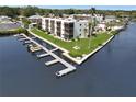 Waterfront condo building with boat docks, manicured lawn, and mature palm trees at 5627 Ferguson Ct # 1303, New Port Richey, FL 34652