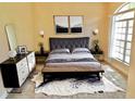 Comfortable main bedroom featuring a decorative rug, a queen bed with neutral bedding, and a sunlit window at 5701 Brackenwood Dr, Spring Hill, FL 34609