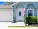 Charming home featuring a welcoming front door with decorative glass and an American flag displayed at 6172 Raleigh St, Spring Hill, FL 34606