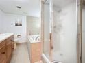 Bright bathroom with a shower stall, garden tub, and vanity featuring wood cabinets and tile flooring at 700 Starkey Rd # 622, Largo, FL 33771