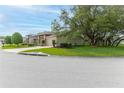 Street view of home with mature trees, manicured lawn, and inviting curb appeal at 7392 Willow Brook Dr, Spring Hill, FL 34606