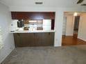 Open kitchen area with a breakfast bar, white appliances, and view to the dining area at 7421 Fairfax Dr, Port Richey, FL 34668