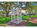 Charming outdoor community bench with decorative pergola and mature trees at 7802 Hardwick Dr # 1116, New Port Richey, FL 34653