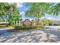 View of the Millpond Trace community entrance sign, lined with shrubs, flowers, and green spaces at 7802 Hardwick Dr # 1116, New Port Richey, FL 34653