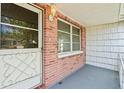 Entrance to a home featuring a decorative door and window with brick and wood details at 7810 Chalafonte Dr, Port Richey, FL 34668