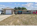 Single-story home featuring a brick facade, attached garage, and a quaint front porch with seating at 7830 Ilex Dr, Port Richey, FL 34668