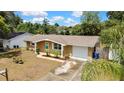 Charming single-story home featuring a well-manicured lawn, complemented by a driveway and attached garage at 7861 Raintree Dr, New Port Richey, FL 34653