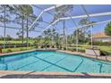 Screened in swimming pool, featuring a brick surround, surrounded by well-maintained landscaping at 8132 Summersong Ct, Spring Hill, FL 34606