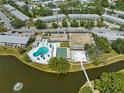 A vibrant aerial view showcases the pool, recreation center, and lake within a residential community at 8405 112Th St # 103, Seminole, FL 33772