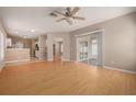 Bright, open-concept living room with laminate flooring, neutral paint, and a sliding glass door at 8526 Hawbuck St, Trinity, FL 34655