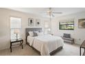 Comfortable bedroom with neutral tones, ample natural light, and a ceiling fan at 8700 Wind Mill Dr, New Port Richey, FL 34655