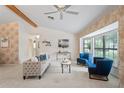 Bright living room featuring neutral carpeting, vaulted ceilings, and large windows for natural light at 8700 Wind Mill Dr, New Port Richey, FL 34655