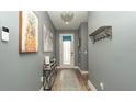 Inviting foyer with light blue walls, wood flooring, and a decorative console table at 905 Old Windsor Way, Spring Hill, FL 34609