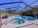 Stunning screened-in pool area features a hot tub, a large in-ground pool, and plenty of room for entertaining at 9152 Bunting Rd, Weeki Wachee, FL 34613