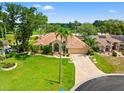Beautifully landscaped home featuring a tile roof and a brick paver driveway, exuding curb appeal at 9161 Southern Comfort Ct, Weeki Wachee, FL 34613