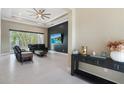 Staged living room with large flat screen, modern ceiling fan and sliders to lanai at 10380 Yellow Hammer Rd, Weeki Wachee, FL 34614
