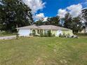 Single-story home with well-maintained lawn and landscaping, light green exterior, and attached garage at 10411 Ireland St, Spring Hill, FL 34608