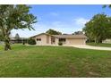 Charming single-story home featuring stone accents, a covered carport, and a well-maintained front lawn at 10441 Mayflower Rd, Spring Hill, FL 34608