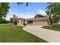 Well-maintained single-story home with neutral tones, stone accents, a two-car garage, and a curved driveway at 10441 Mayflower Rd, Spring Hill, FL 34608