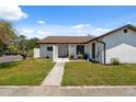 Charming single-story home with neutral paint, brown roof, landscaping, and a walkway at 11402 Shallowbrook Pl, Tampa, FL 33624