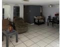 An open living room with tile floors, featuring a seating area, dining table, and mirrors at 11726 Oceanside Dr, Port Richey, FL 34668