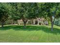Attractive home surrounded by mature trees and a well-kept lawn at 12403 Moneta Rd, Weeki Wachee, FL 34614