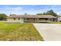 Single story home featuring stone accents, a covered parking area, and a well maintained lawn at 12936 Parkwood St, Hudson, FL 34669