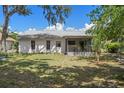 A view of the backyard showing a screened-in porch and sparse lawn at 13307 Woodward Dr, Hudson, FL 34667