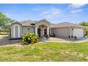 A charming home featuring a well-manicured lawn and attached two car garage at 14031 Hexam Rd, Brooksville, FL 34613