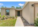 View of front door showcasing the walkway, front yard landscaping, and neutral-toned exterior at 15414 Green Jay Rd, Weeki Wachee, FL 34614