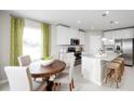 Bright dining area next to a modern kitchen featuring a wooden table, comfortable seating, and large windows at 1699 W Palms Dr, Port Charlotte, FL 33953