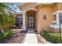 Close-up view of the home's inviting front entrance featuring double doors and manicured landscaping at 18223 Nestlebranch Ct, Hudson, FL 34667