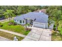 Charming single-story home with manicured lawn, palm trees, and a three-car garage at 18902 Saint Laurent Dr, Lutz, FL 33558