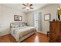 Cozy bedroom with hardwood floors, a comfortable queen-sized bed, a ceiling fan, and natural light from the window at 1987 Trillium Blvd, Brooksville, FL 34604