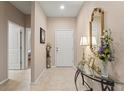 Inviting foyer with tile flooring, decorative mirror, table with floral arrangement, and a view into other rooms at 1987 Trillium Blvd, Brooksville, FL 34604