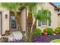 The front entrance landscape features various plants, including palm trees, colorful flowers, and neatly arranged mulch at 1987 Trillium Blvd, Brooksville, FL 34604