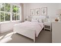 Serene bedroom showcasing a pink comforter, white furniture, and garden views at 20088 Golden Glow Loop, Venice, FL 34292