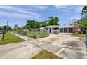 Quaint home featuring a well-maintained yard, screened in porch, and long driveway at 2012 Warrington Way, Tampa, FL 33619