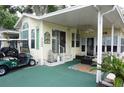 Charming home exterior featuring a covered porch, well-manicured landscaping, and a convenient golf cart parking area at 21040 Lazy Days Cir, Lutz, FL 33558