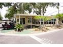 Charming home exterior featuring a covered porch, well-manicured landscaping, and a convenient golf cart parking area at 21040 Lazy Days Cir, Lutz, FL 33558