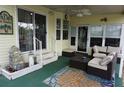 Inviting covered patio with comfortable seating, perfect for relaxation and entertaining with a ceiling fan and outdoor rug at 21040 Lazy Days Cir, Lutz, FL 33558