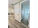 Hallway leading to an open-concept living room with wood-look flooring at 3304 Honeymoon Ln, Holiday, FL 34691